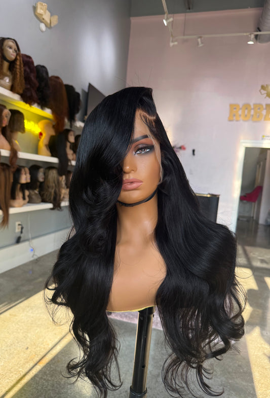Extra dense wig with a body wave texture, natural color, and left side part; front view.