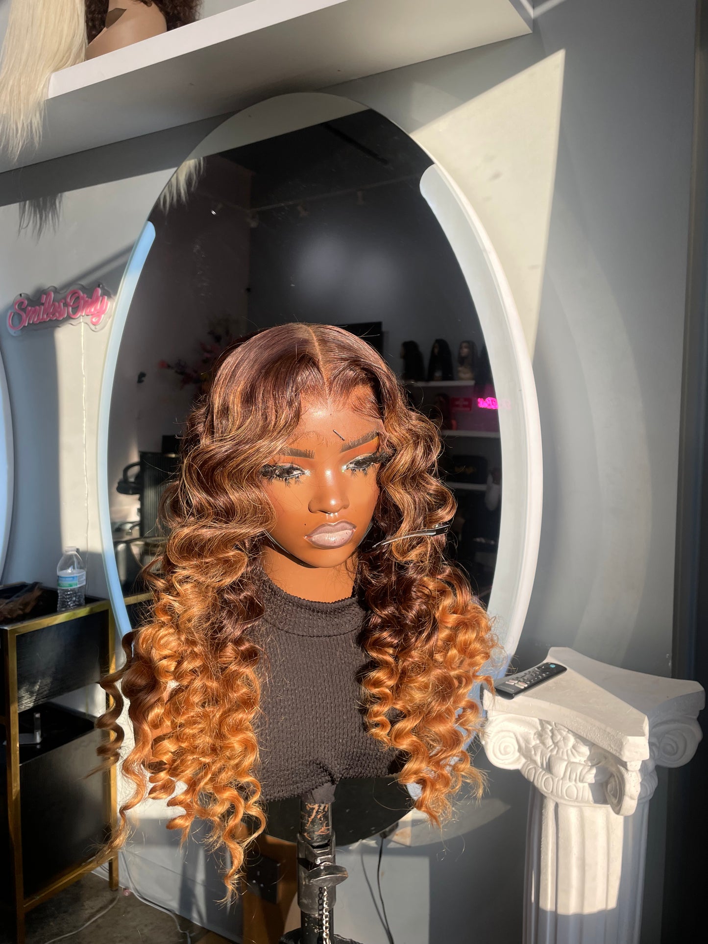Natural color wig with wands curls and bottom half being an orange color; front view.