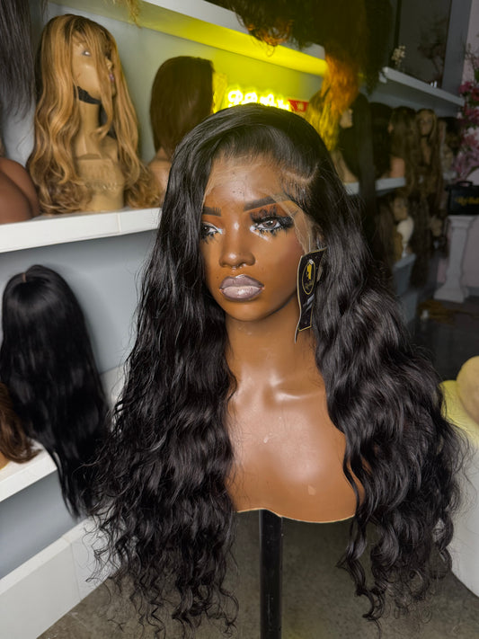 Natural color wig with a loose wave texture and left side part; front view.