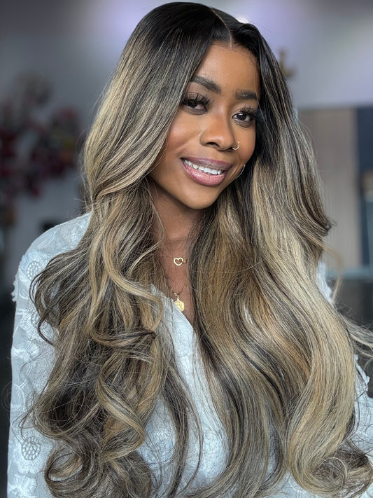 Woman wearing a raw Indian hair wig with custom highlights, front view.