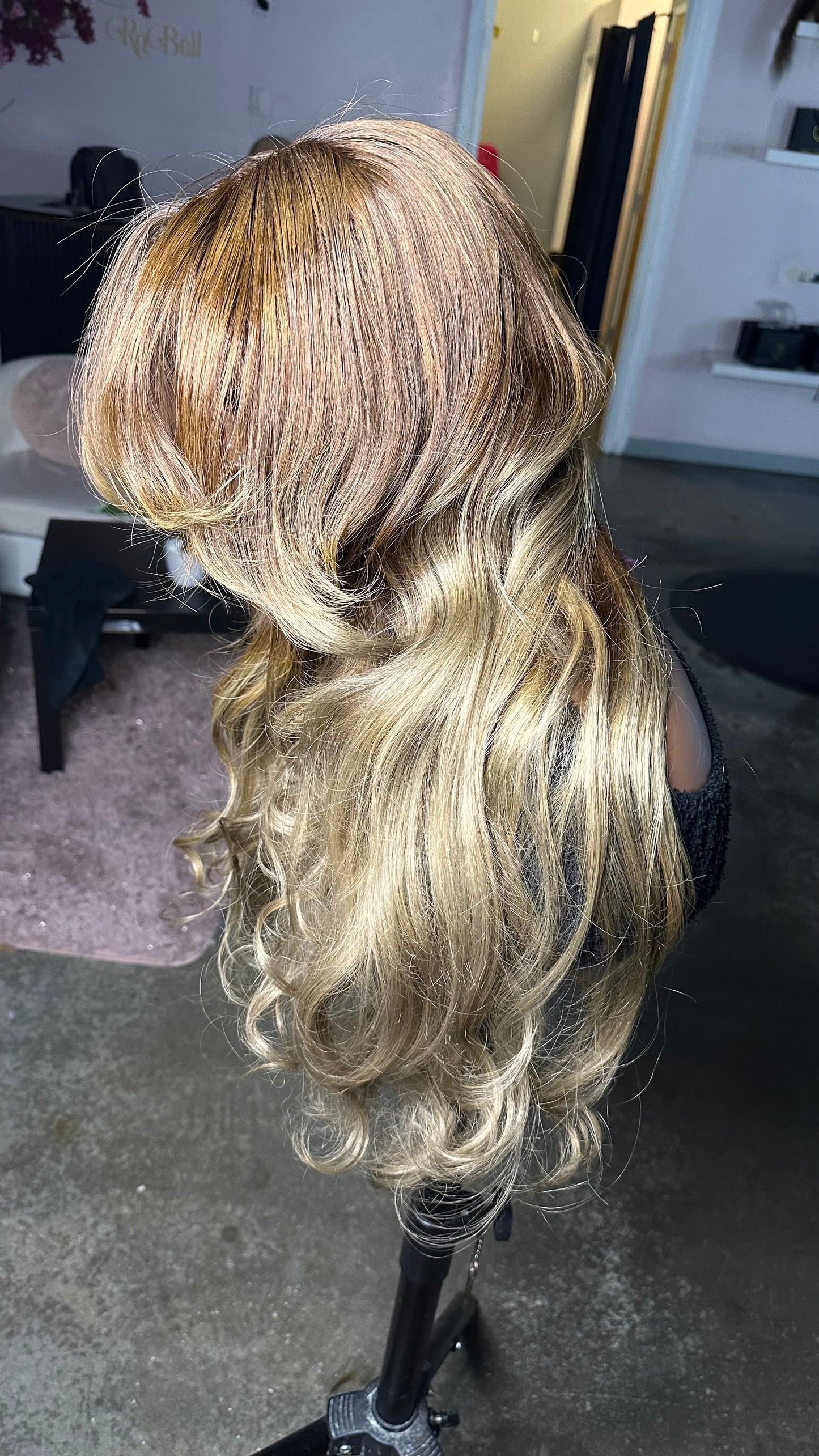 Human hair wig with brown roots and a light blonde color; left side view.