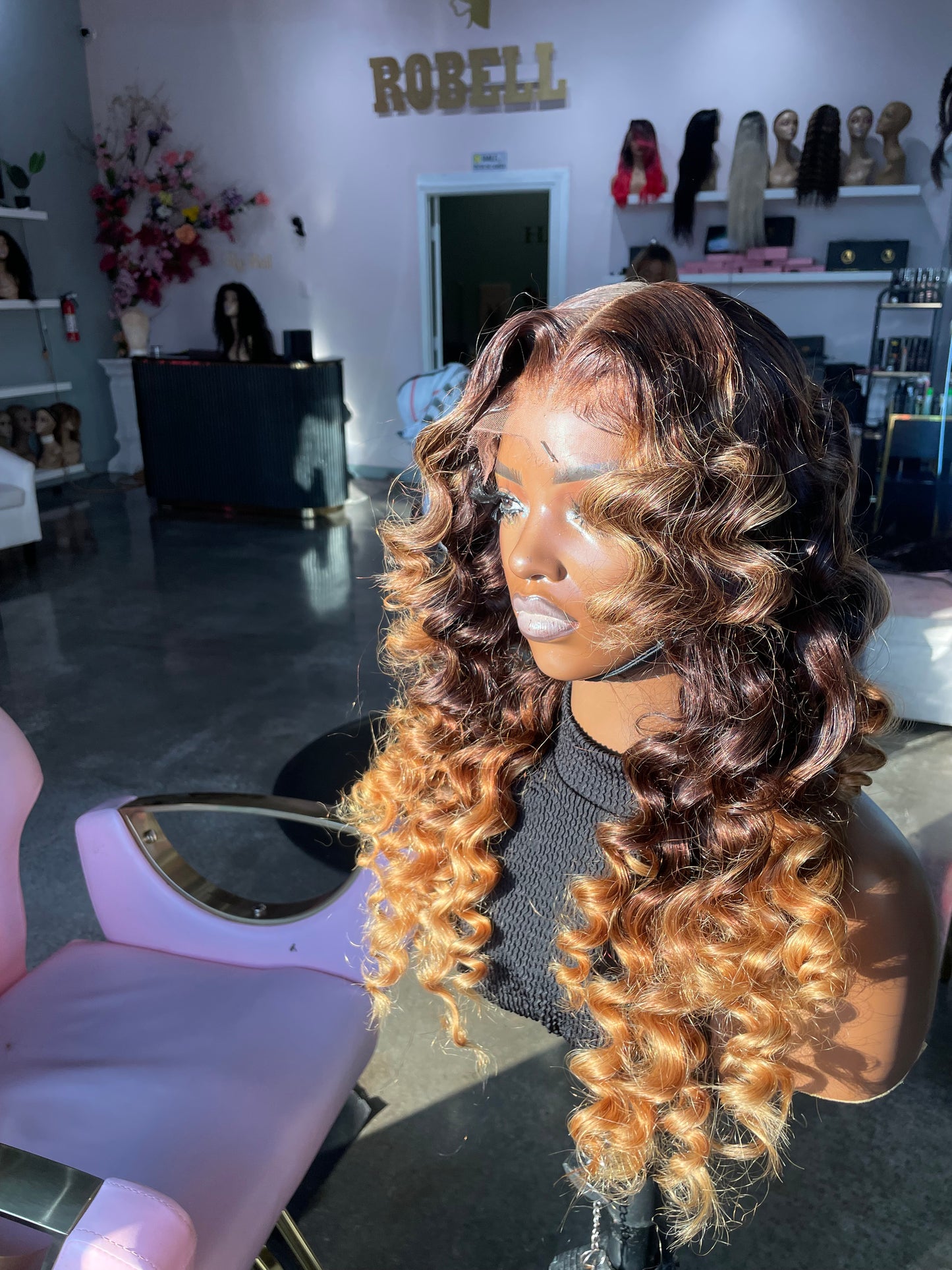 Natural color wig with wands curls and bottom half being an orange color; front right quarter view.