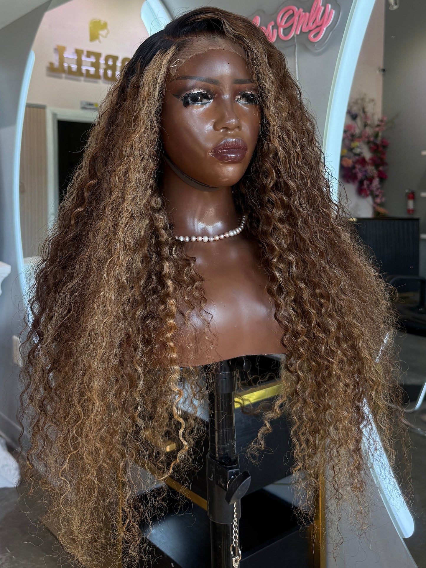 Front left view of deep curly blonde wig.