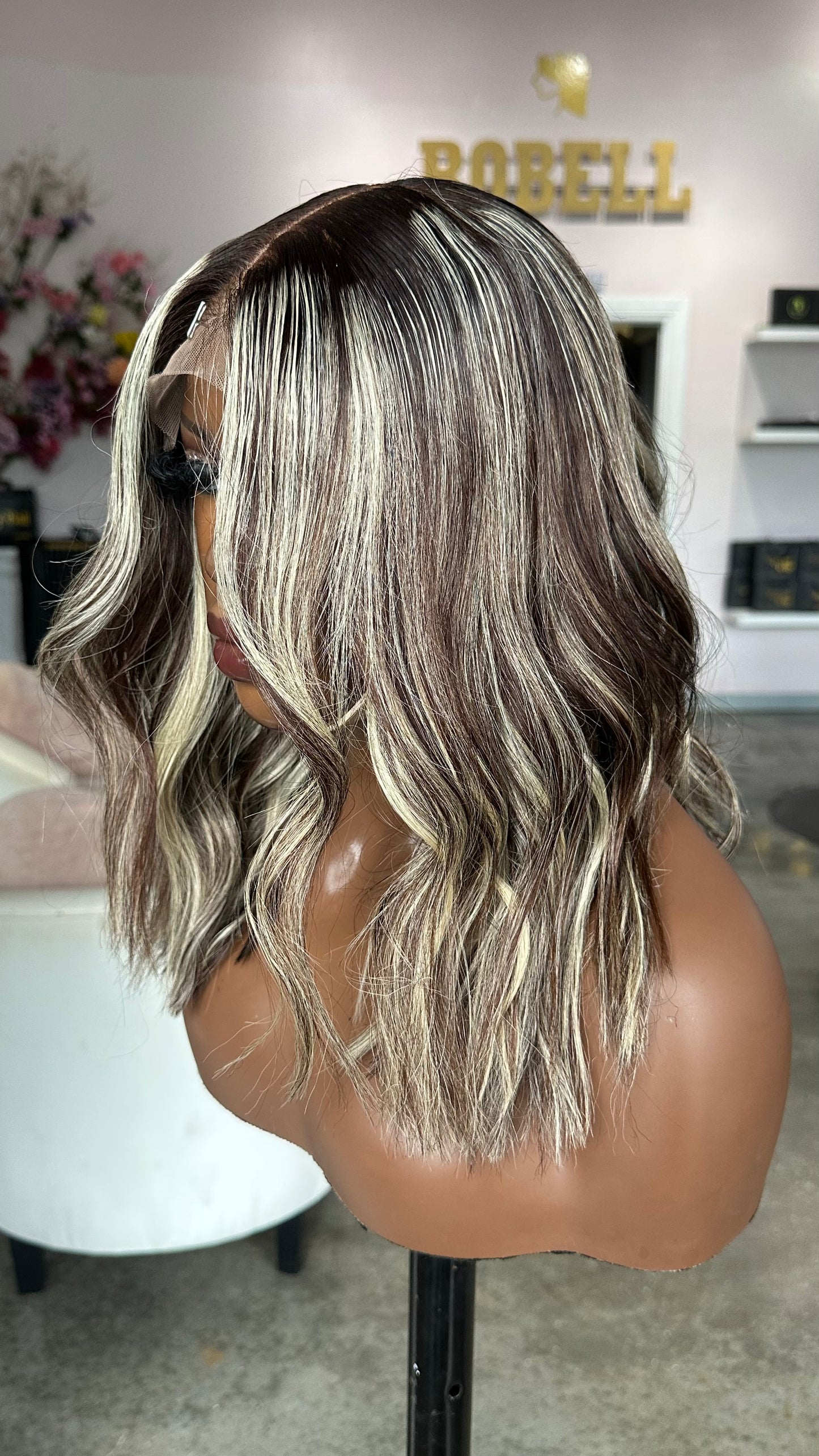 Short wig with dark roots and white highlights.