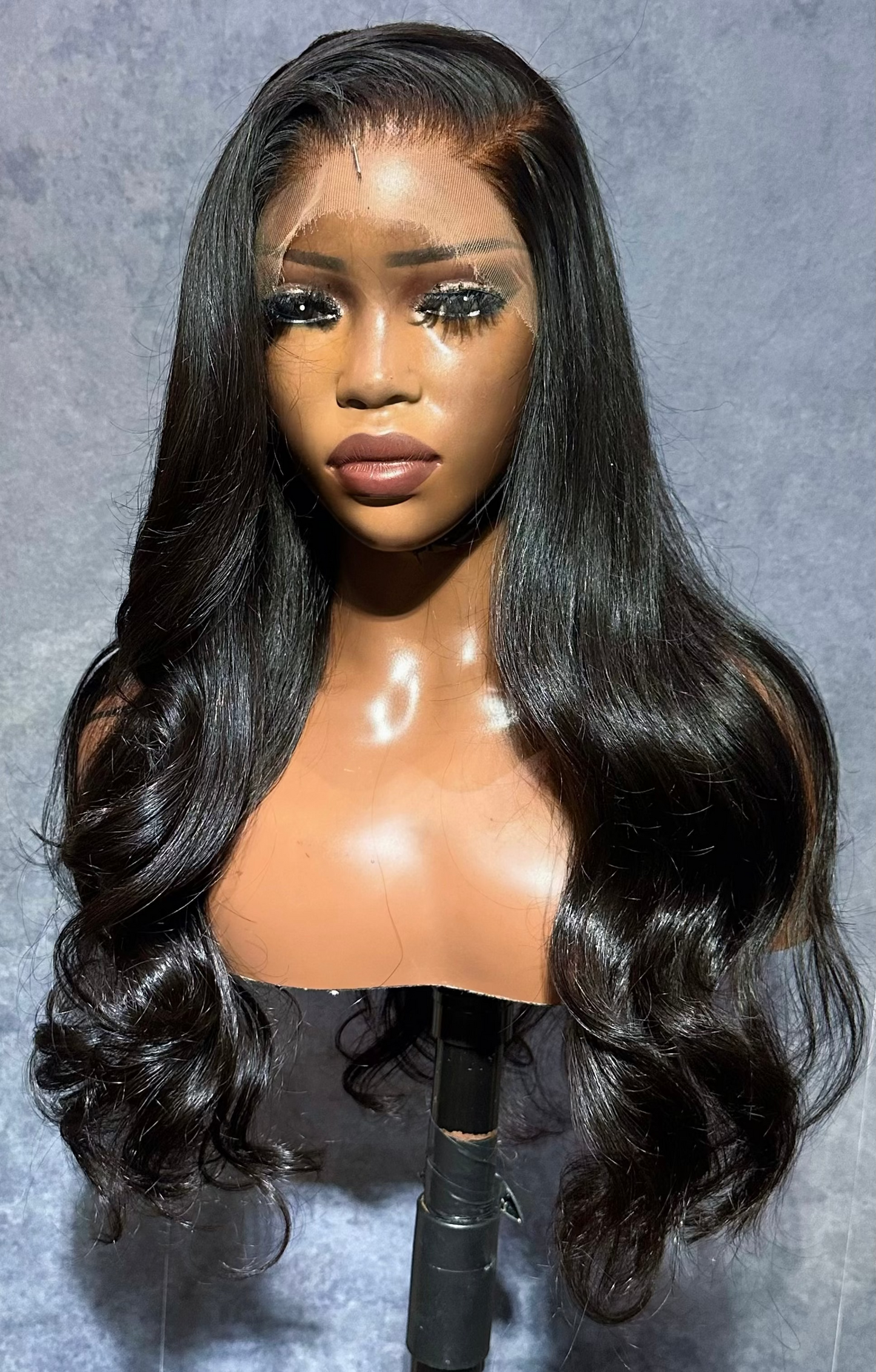 Black wig on a mannequin head against a gray background made with a lace frontal