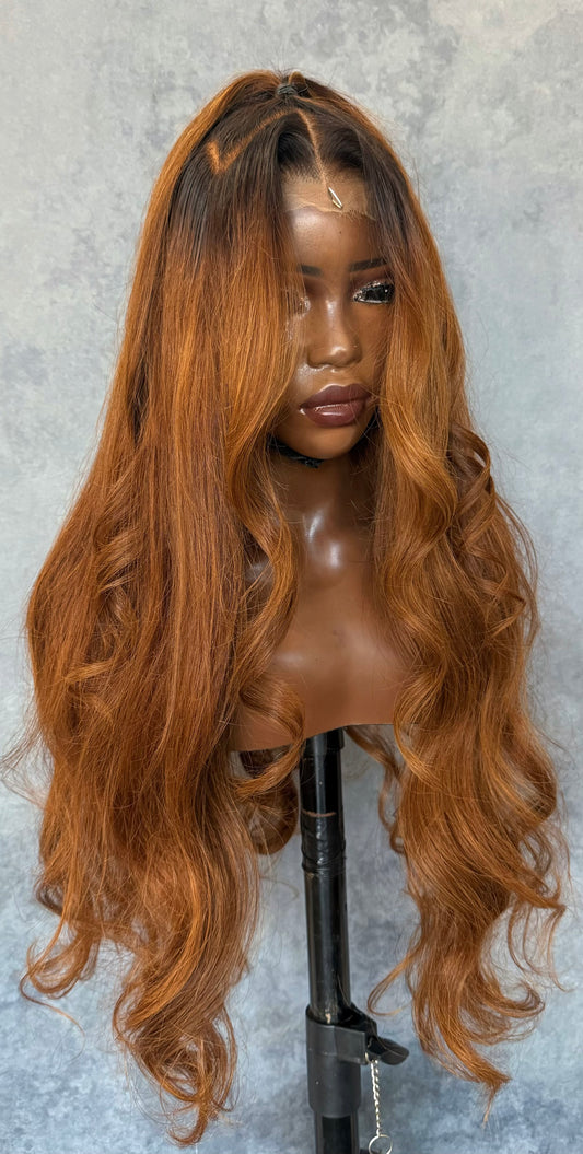 Brown wig on a mannequin head against a gray background with a ponytail.