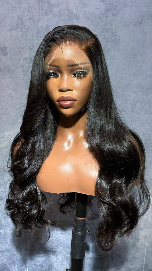 Black wig on a mannequin head against a gray background